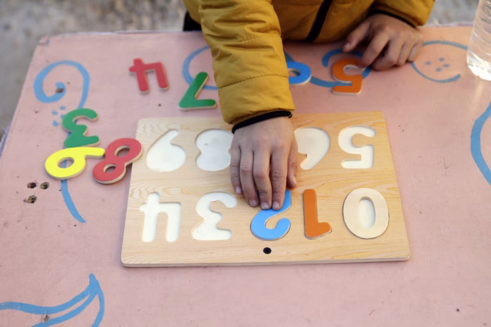 Boy Playing With Wooden Numbers Puzzle